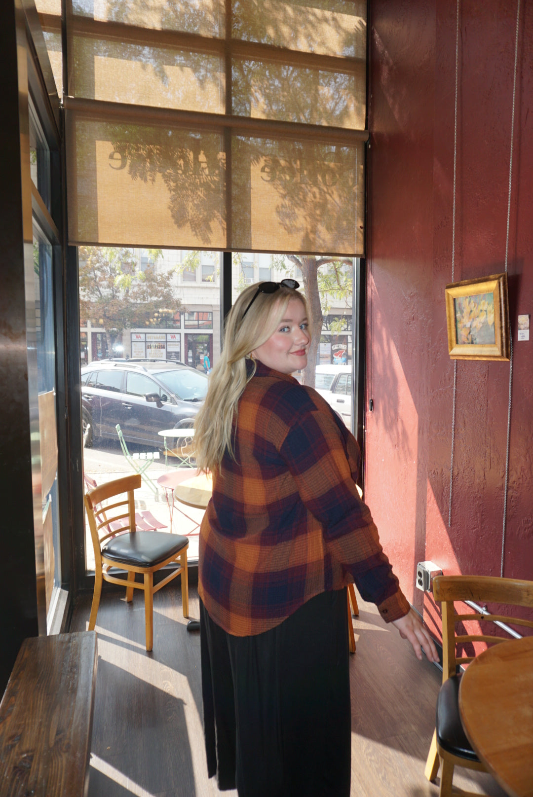 A flannel style button up shirt, with orange, blue, and red autumnal colors. 
