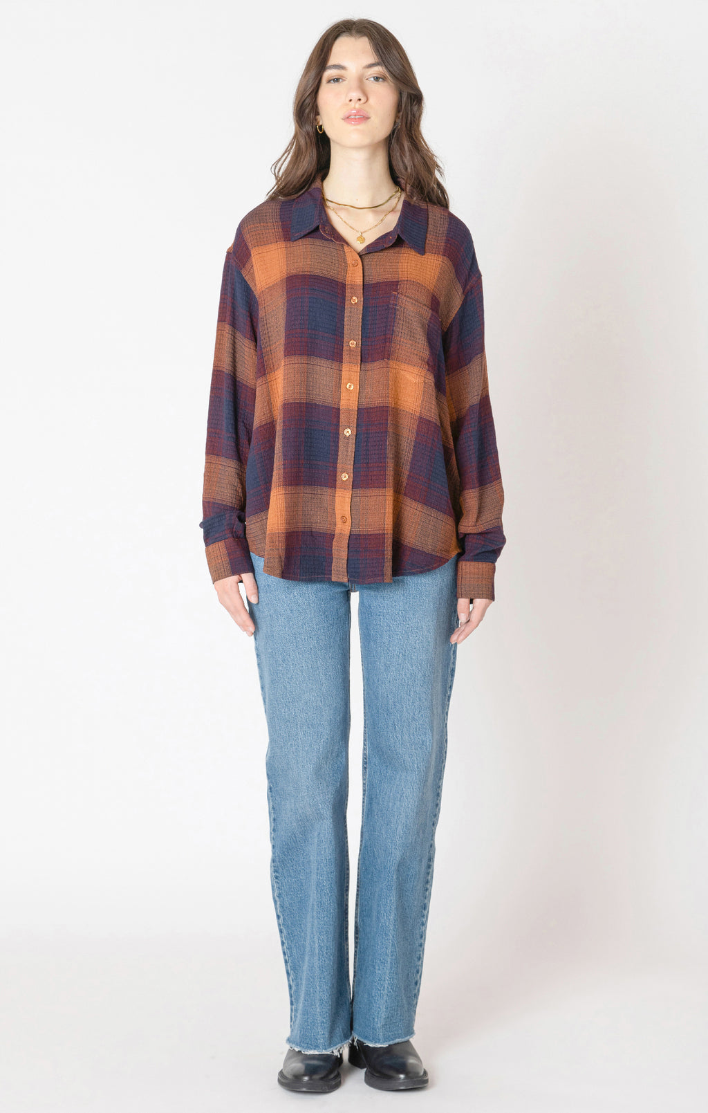 A flannel style button up shirt, with orange, blue, and red autumnal colors. 