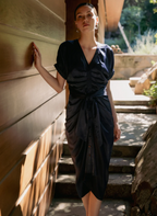 Women wearing a satin dress with buttons and tie front standing outside