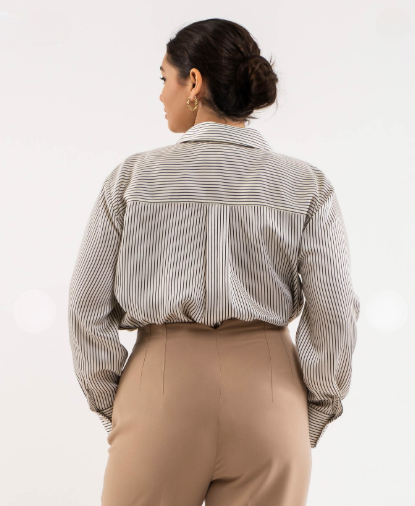 Person wearing a striped shirt and beige pants on a white background
