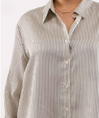 Close-up of a person wearing a striped shirt with a plain background