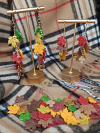Autumn leaf polymer clay earrings displayed on a gold earring stand for  craft club event