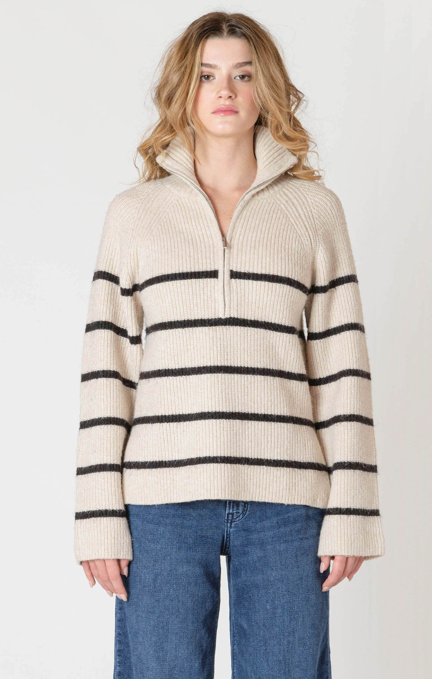 A cozy cream sweater with horizontal black stripes, and a half zipper, and a collar.
