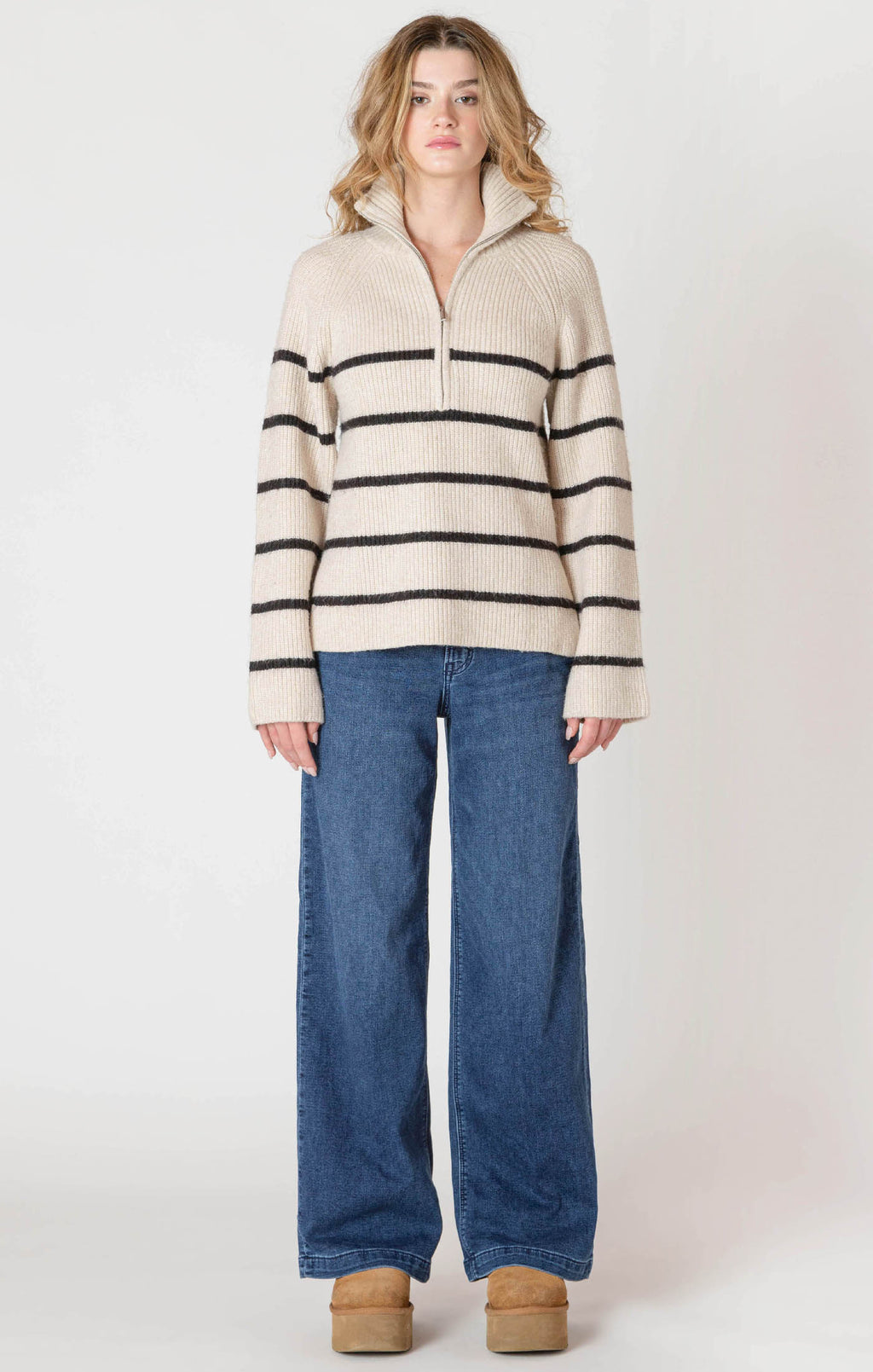 A cozy cream sweater with horizontal black stripes, and a half zipper, and a collar.