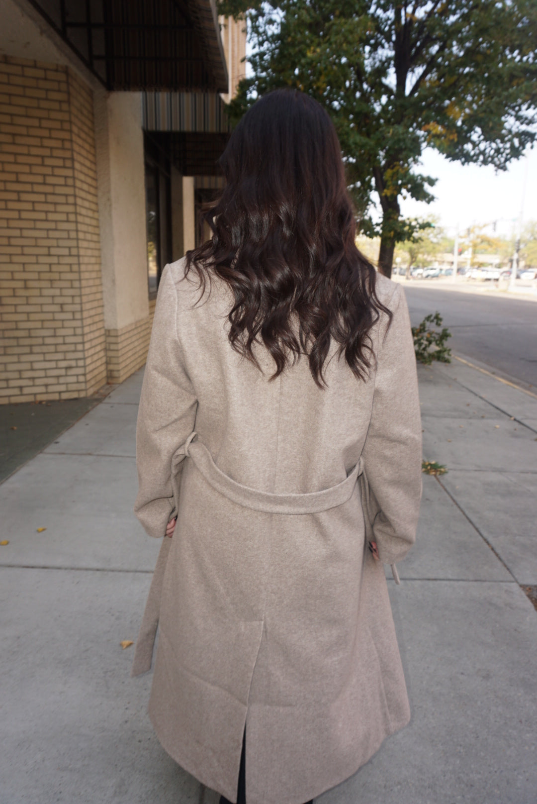 A beautiful and timeless oat colored coat, with a tie waste, a trench like lapel, and pockets.