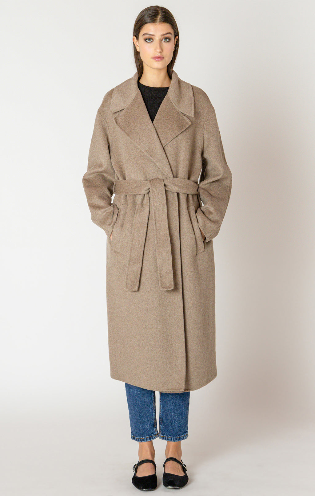 A beautiful and timeless oat colored coat, with a tie waste, a trench like lapel, and pockets.