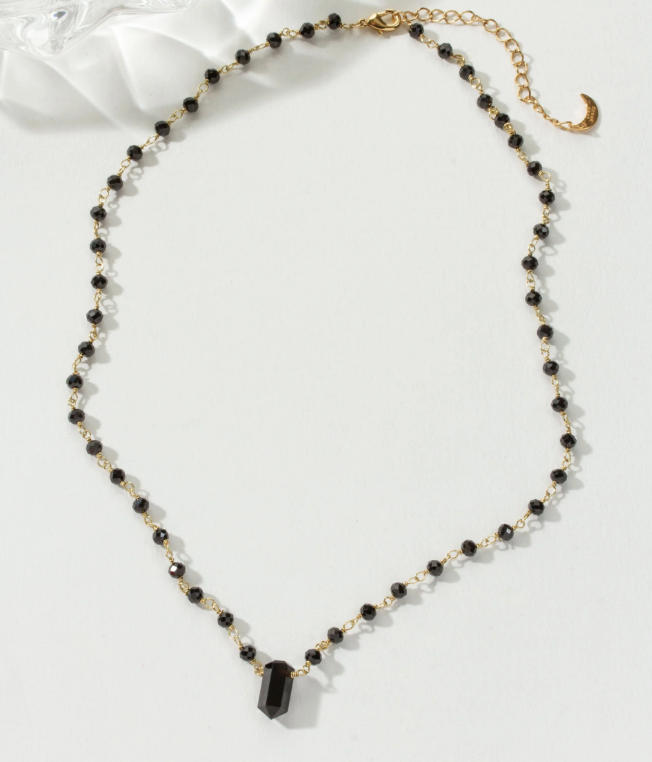 Necklace with black beads and gold chain with an onyx point center stone.