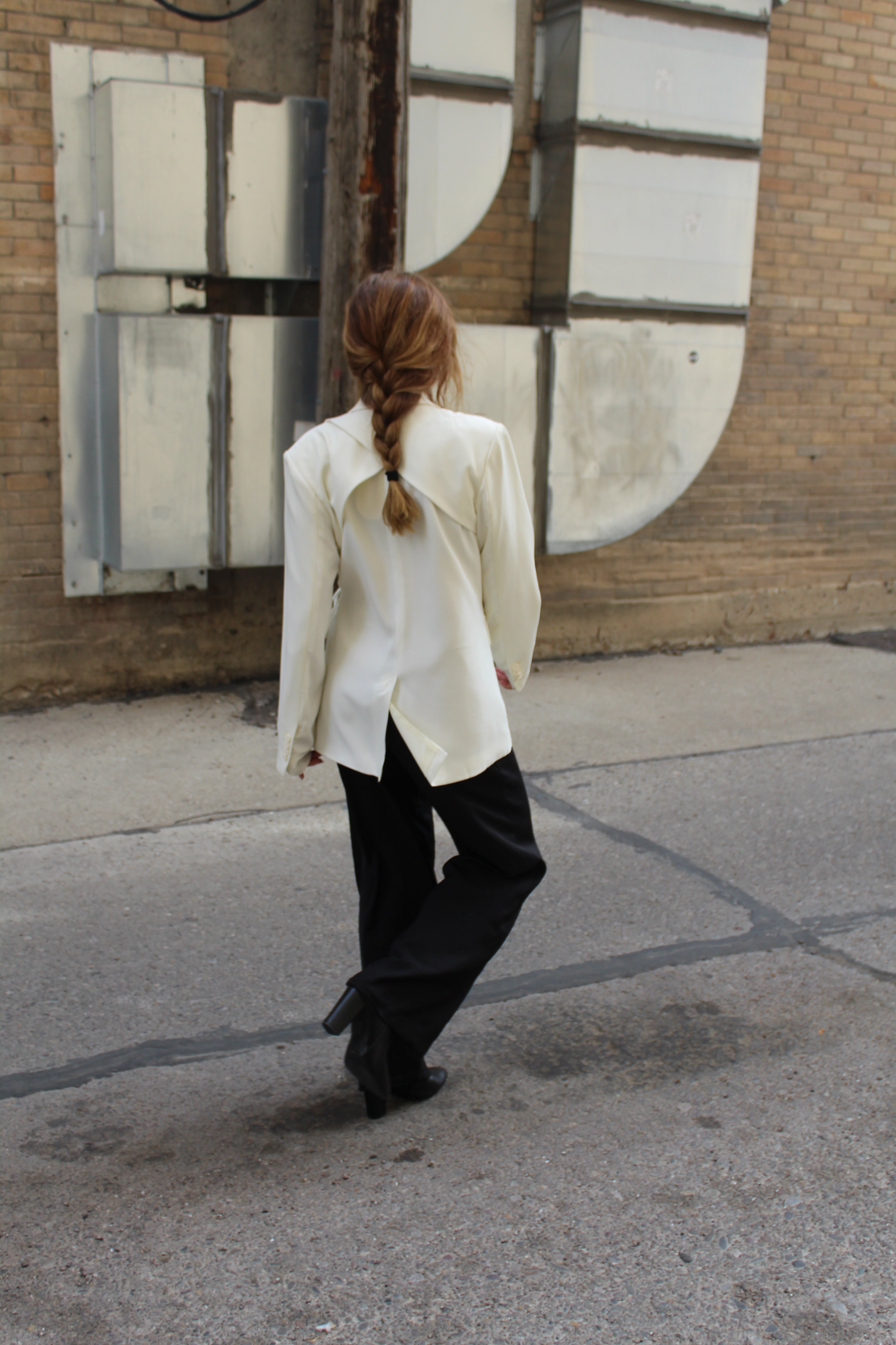 A white suite jacket with a shoulder blade vent detail.
