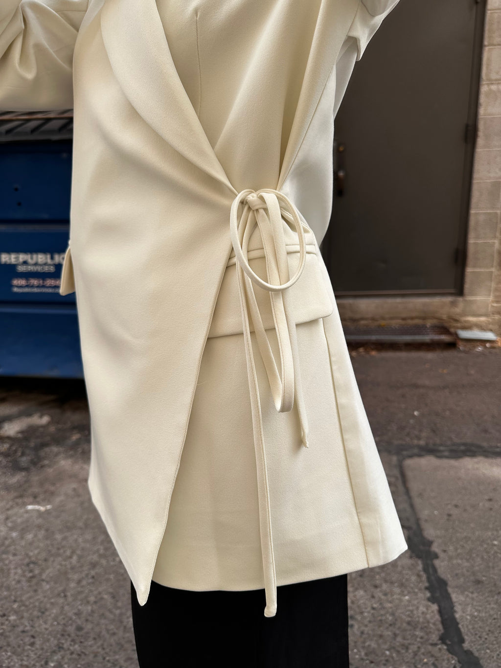 A sharp white blazer with a side tie detail.