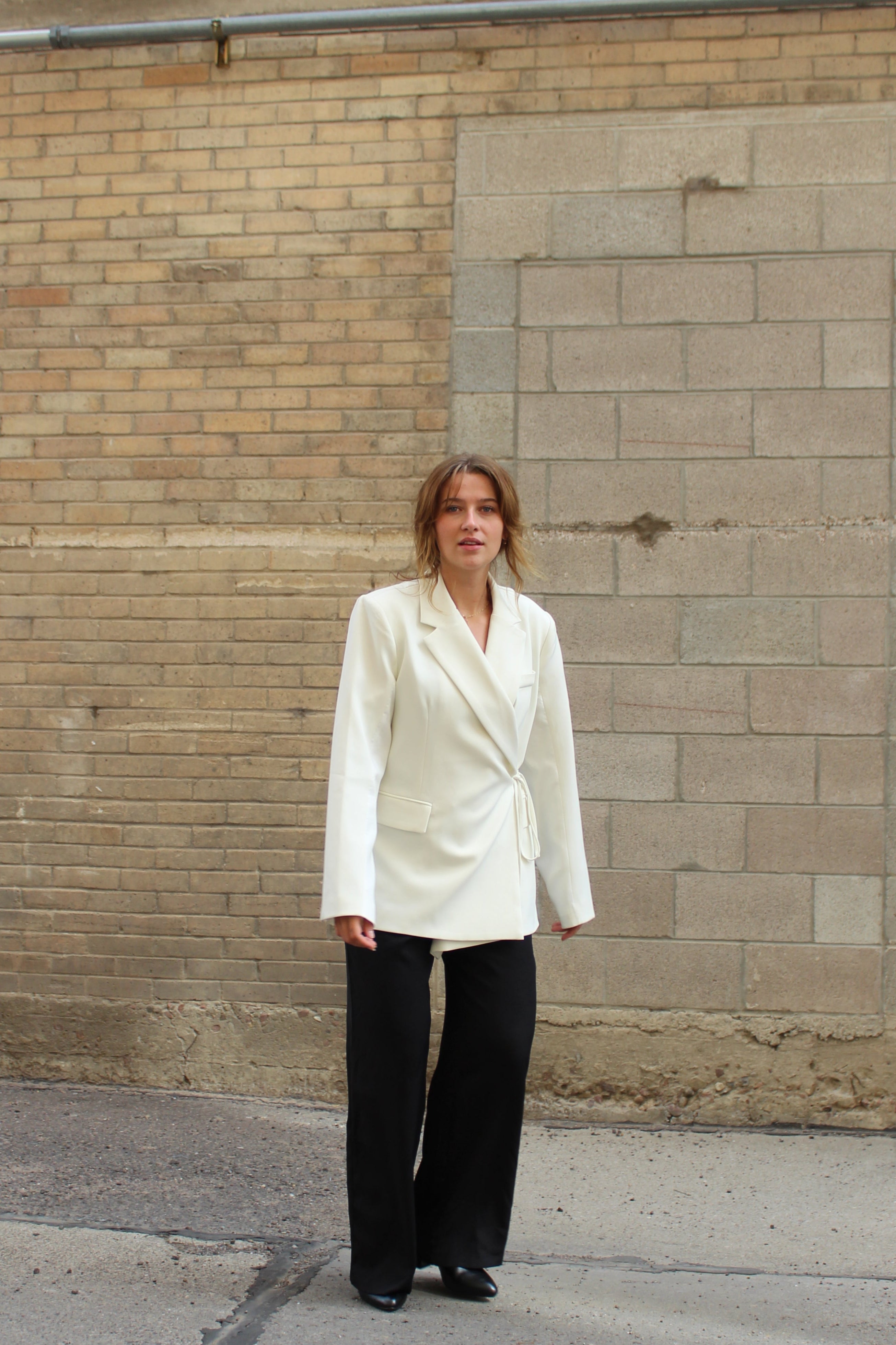 A white suite jacket with a side tie detail.