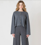 Woman wearing a gray outfit with a matching cardigan and pants on a white background