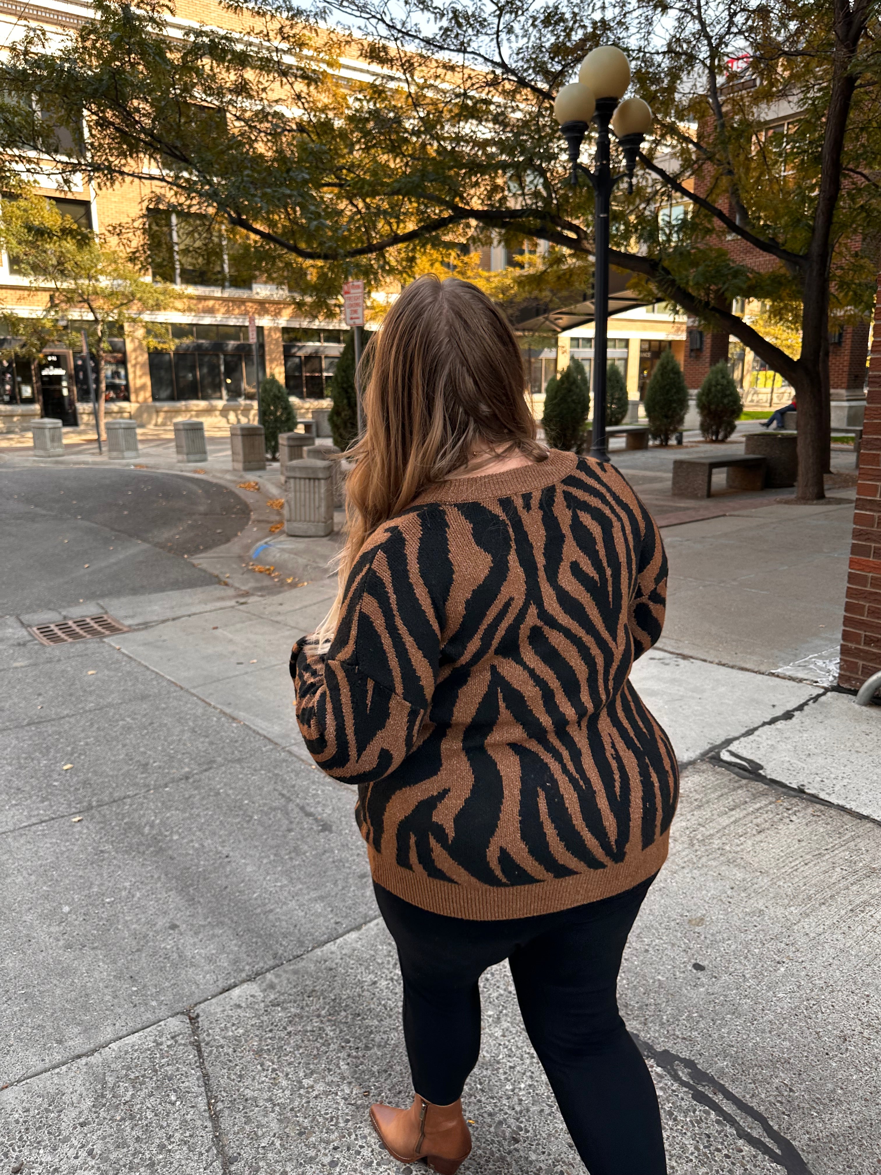A luxuriously soft brown cardigan, with black animal print striping, pockets, and a button down front.