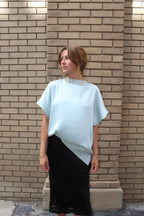 A minty green satin top with a unique neck detail.