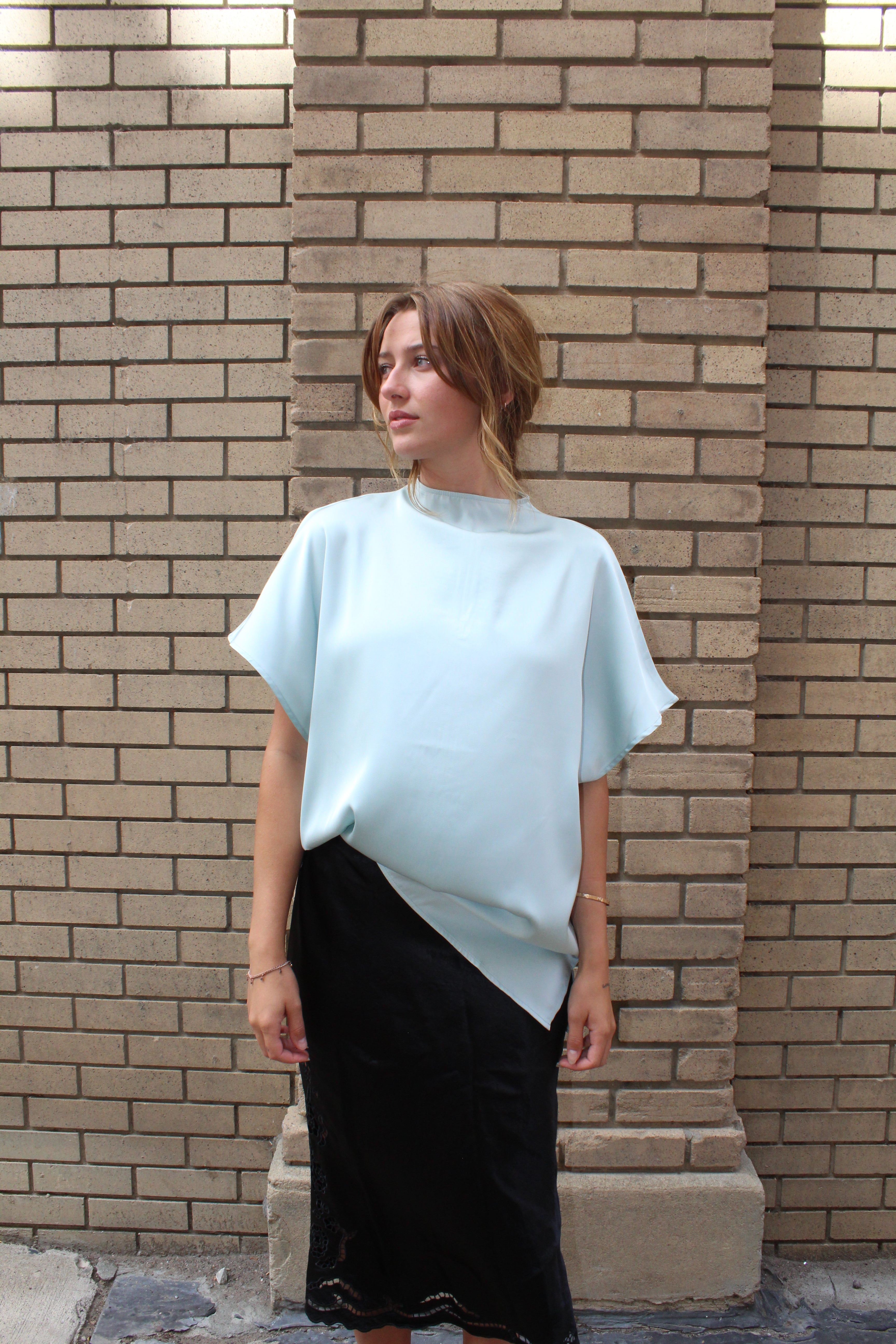 A minty green satin top with a unique neck detail.