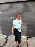 A minty green satin top with a unique neck detail.