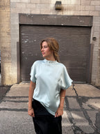 A minty green satin top with a unique neck detail.