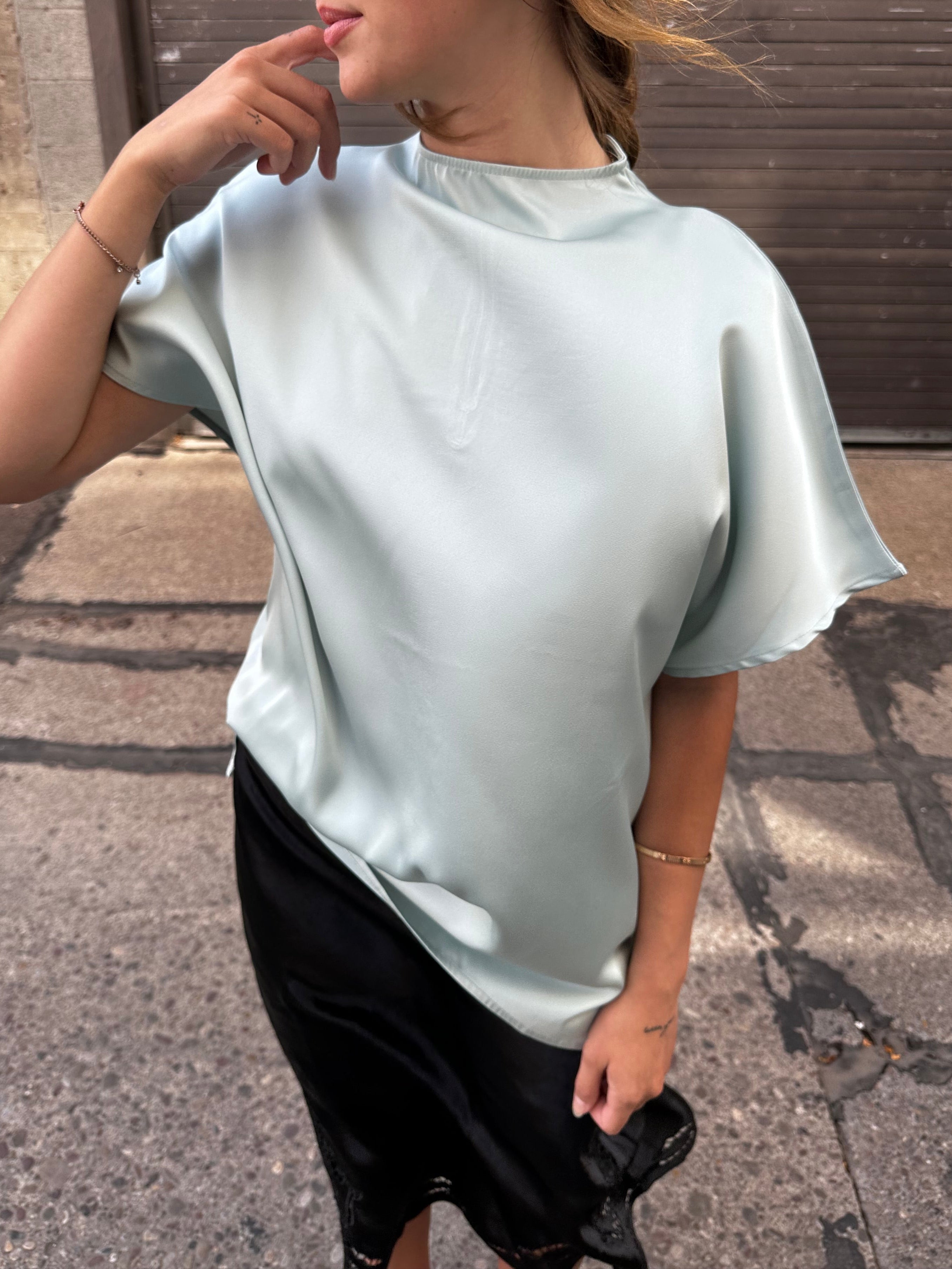 A minty green satin top with a unique neck detail.