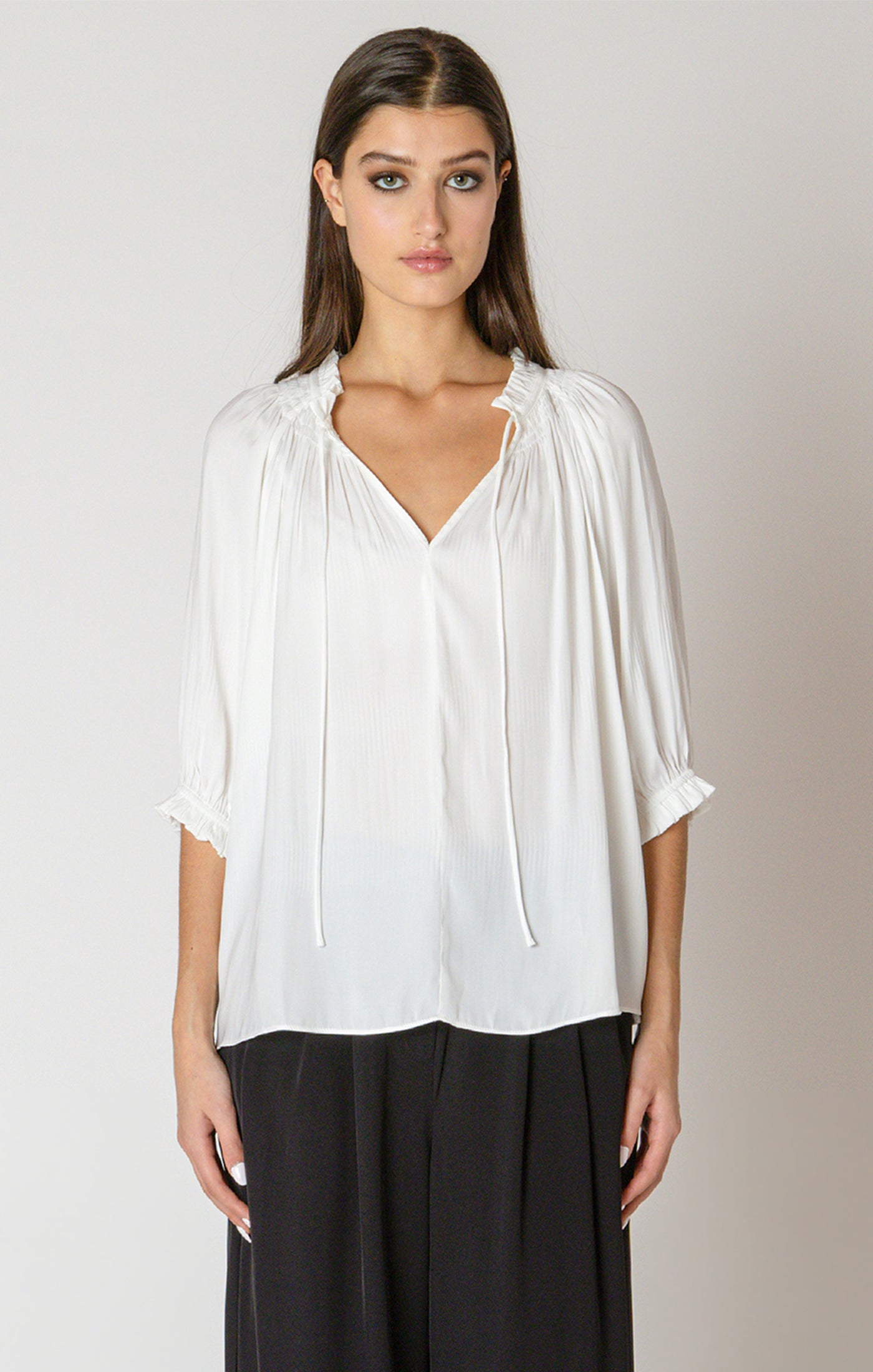 A beautiful white blouse, with a drawstring neck detail, and cinched 3/4 length sleeves.