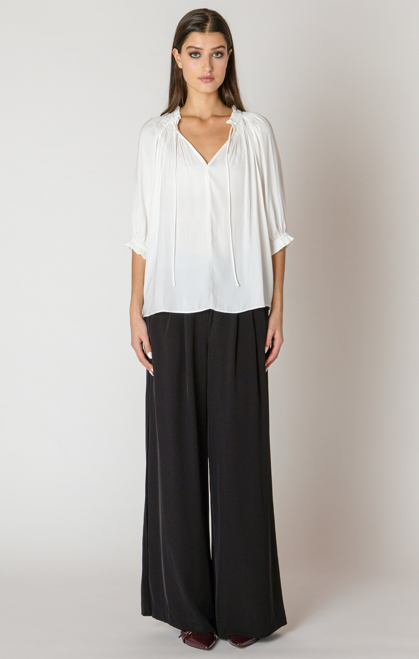 A beautiful white blouse, with a drawstring neck detail, and cinched 3/4 length sleeves.