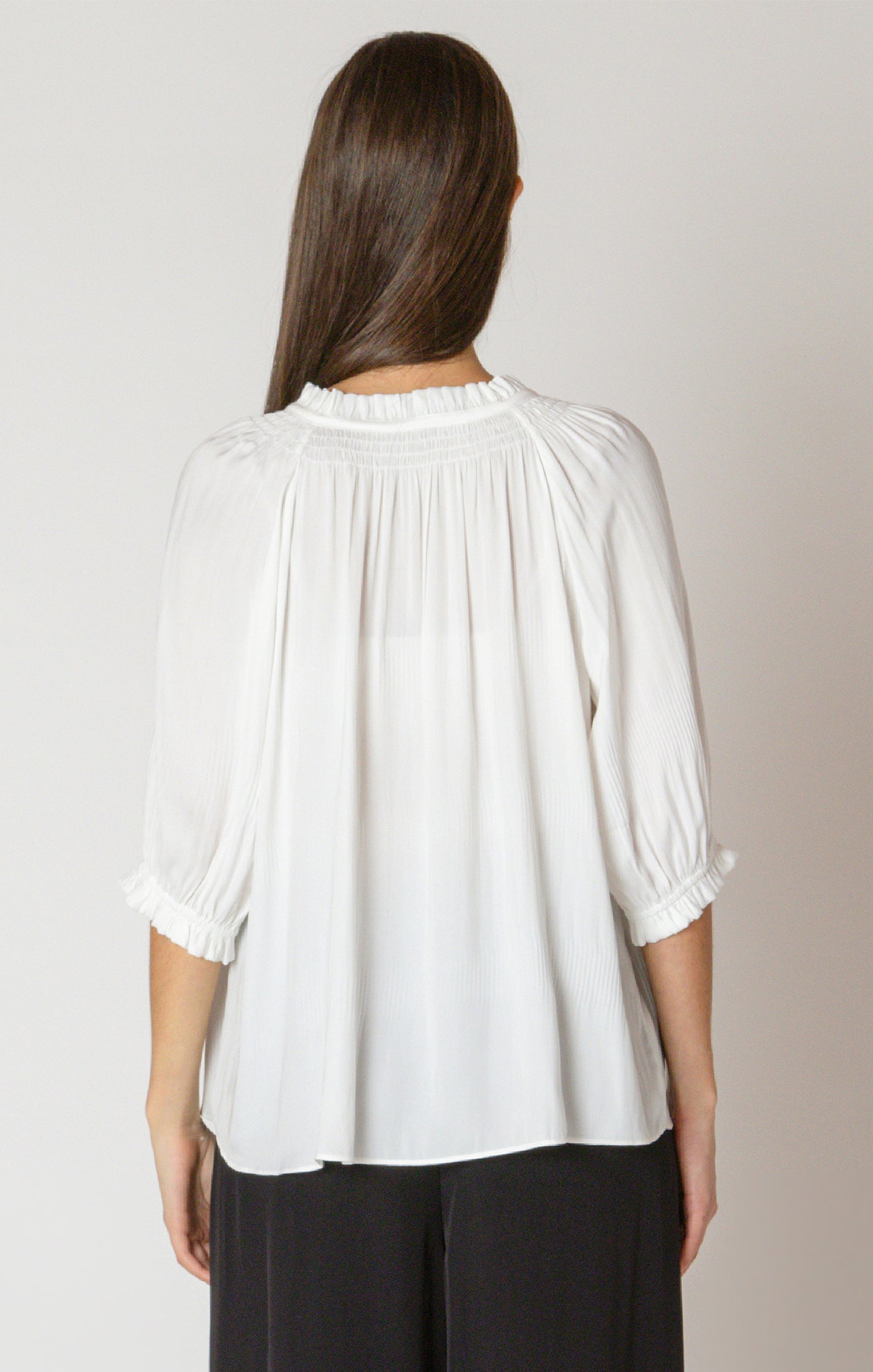 A beautiful white blouse, with a drawstring neck detail, and cinched 3/4 length sleeves.