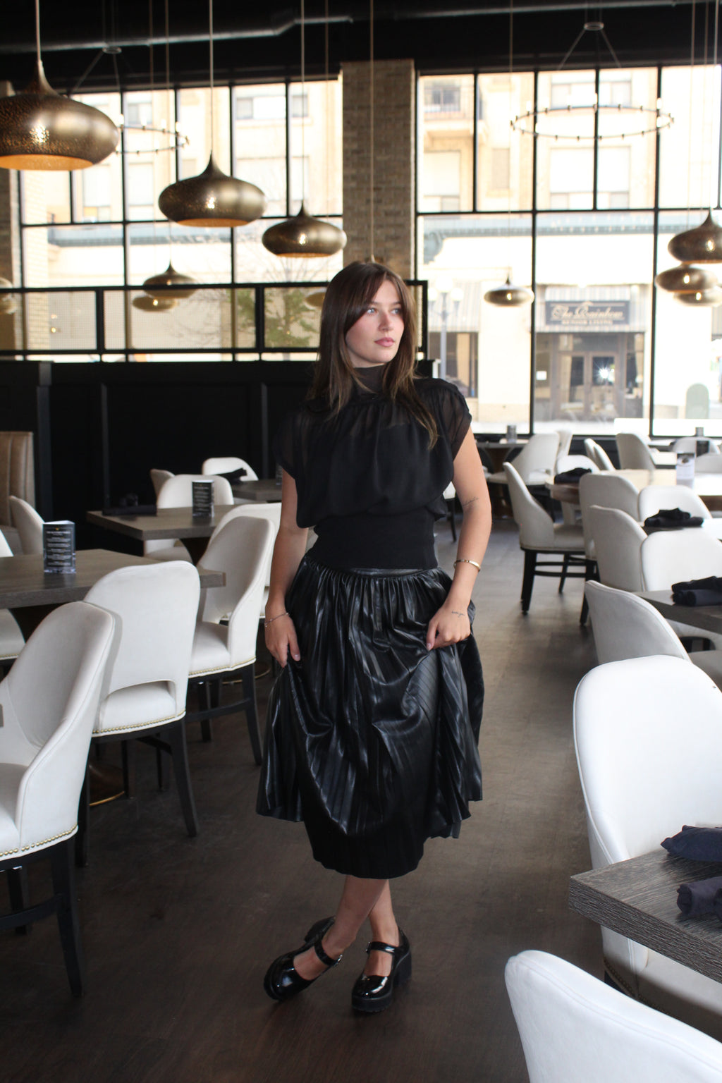 A chiq black sheer top with a gathered waist, mock neck, and cap sleeves.