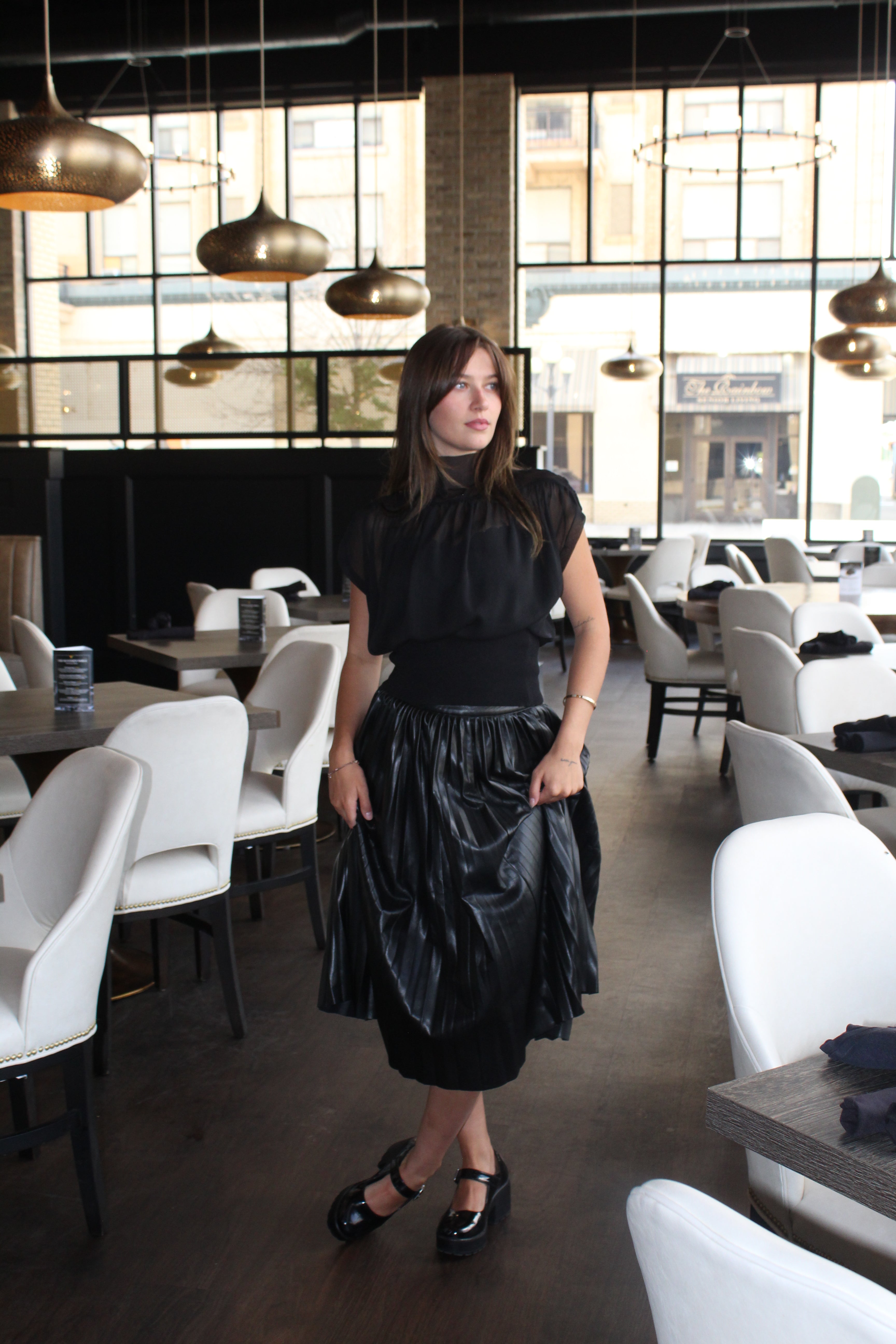 A chiq black sheer top with a gathered waist, mock neck, and cap sleeves.