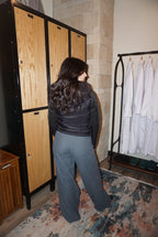 A black puffer jacket with a hood, and thick, stretchy, knitted sleeves.