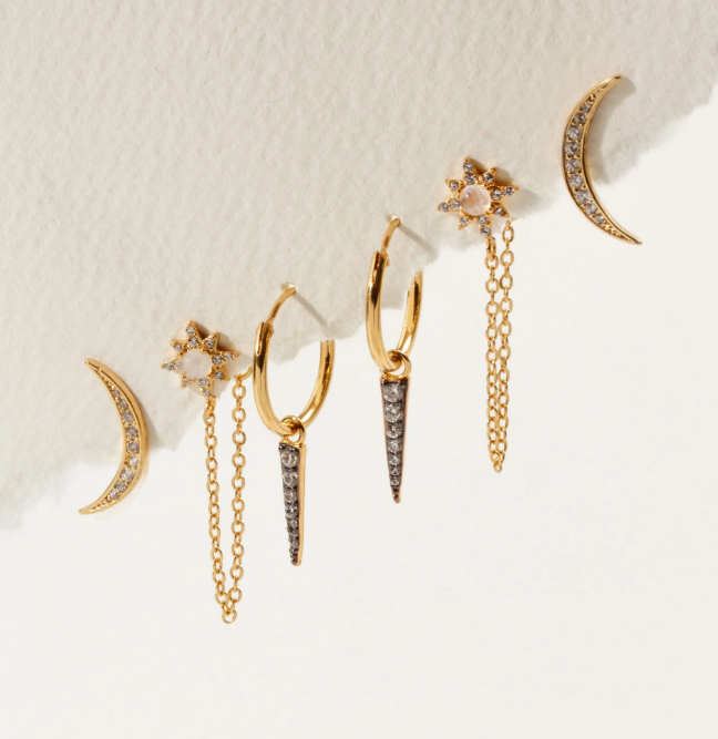 Collection of gold earrings with various designs on a light background