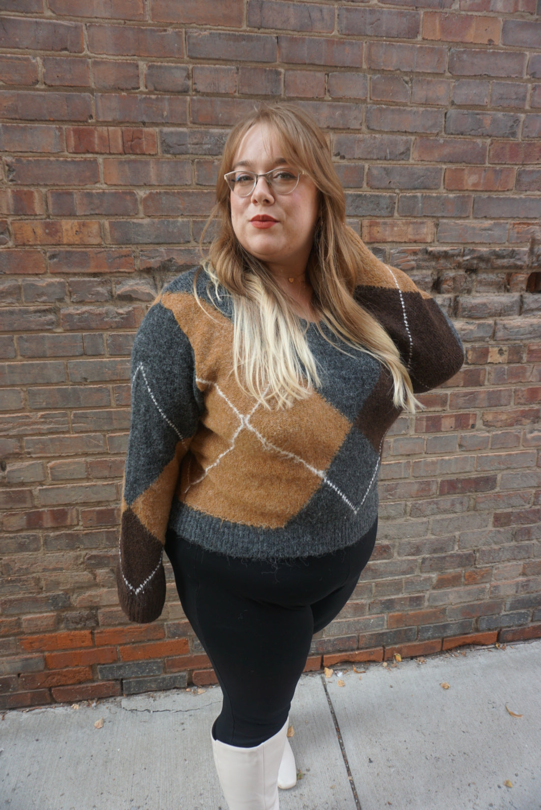 A cozy argyle sweater, with charcoal, tan, brown, and white colors, creating a timeless piece perfect for chilly winter days.
