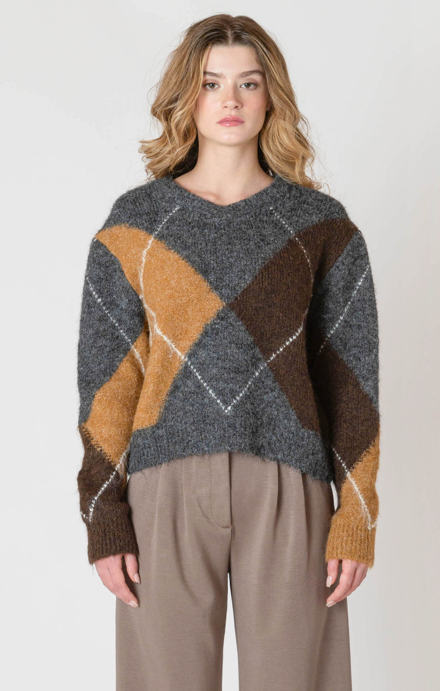 A cozy argyle sweater, with charcoal, tan, brown, and white colors, creating a timeless piece perfect for chilly winter days.