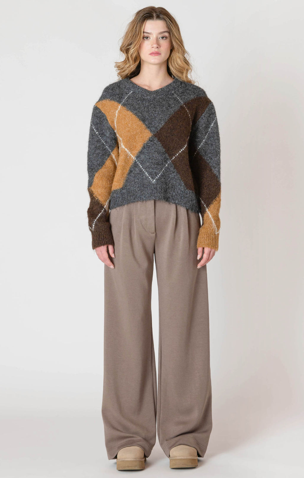 A cozy argyle sweater, with charcoal, tan, brown, and white colors, creating a timeless piece perfect for chilly winter days.