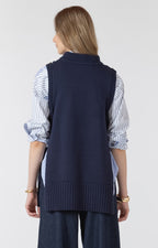 Person wearing a navy blue vest over a striped shirt on a white background