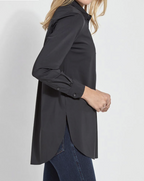 Person wearing a black long-sleeve shirt with a plain background