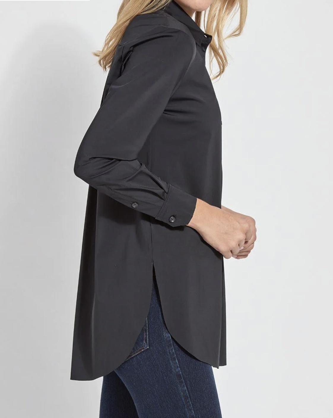 Person wearing a black long-sleeve shirt with a plain background