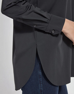 Black shirt with a buttoned front and blue jeans on a plain background