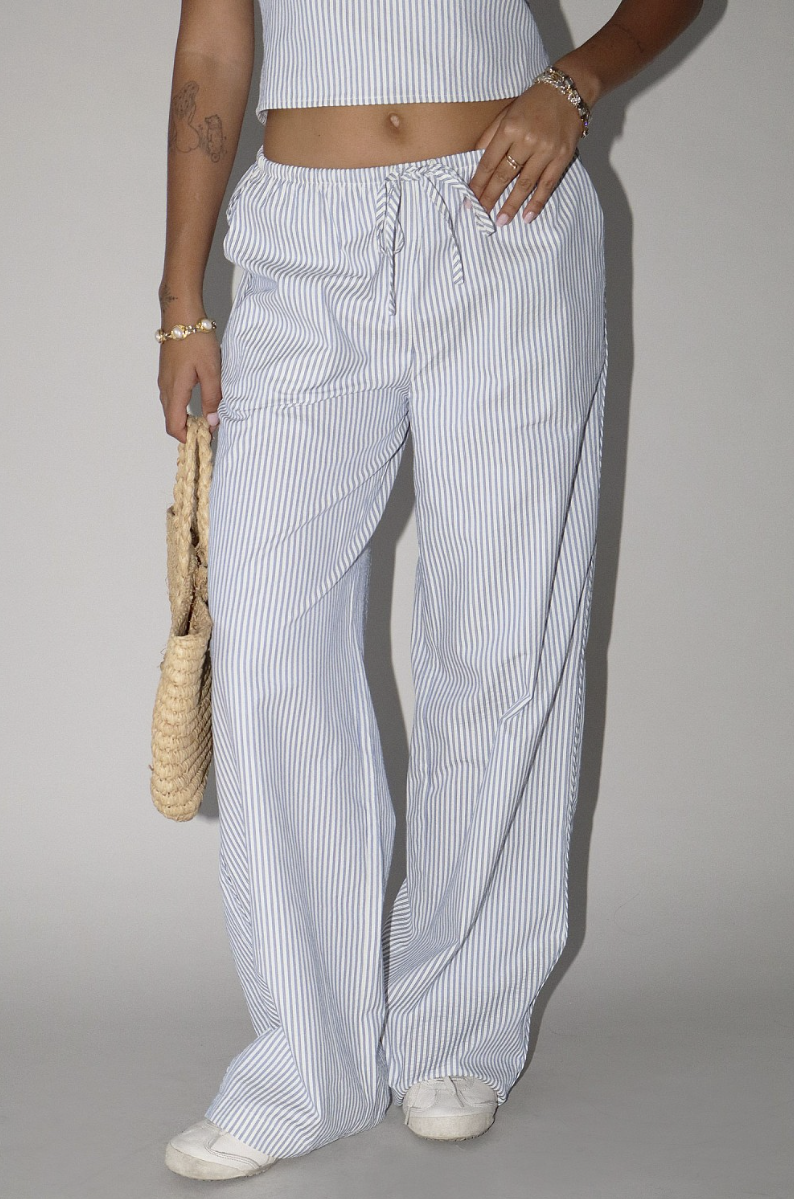 Person wearing blue and white striped pants with a plain background