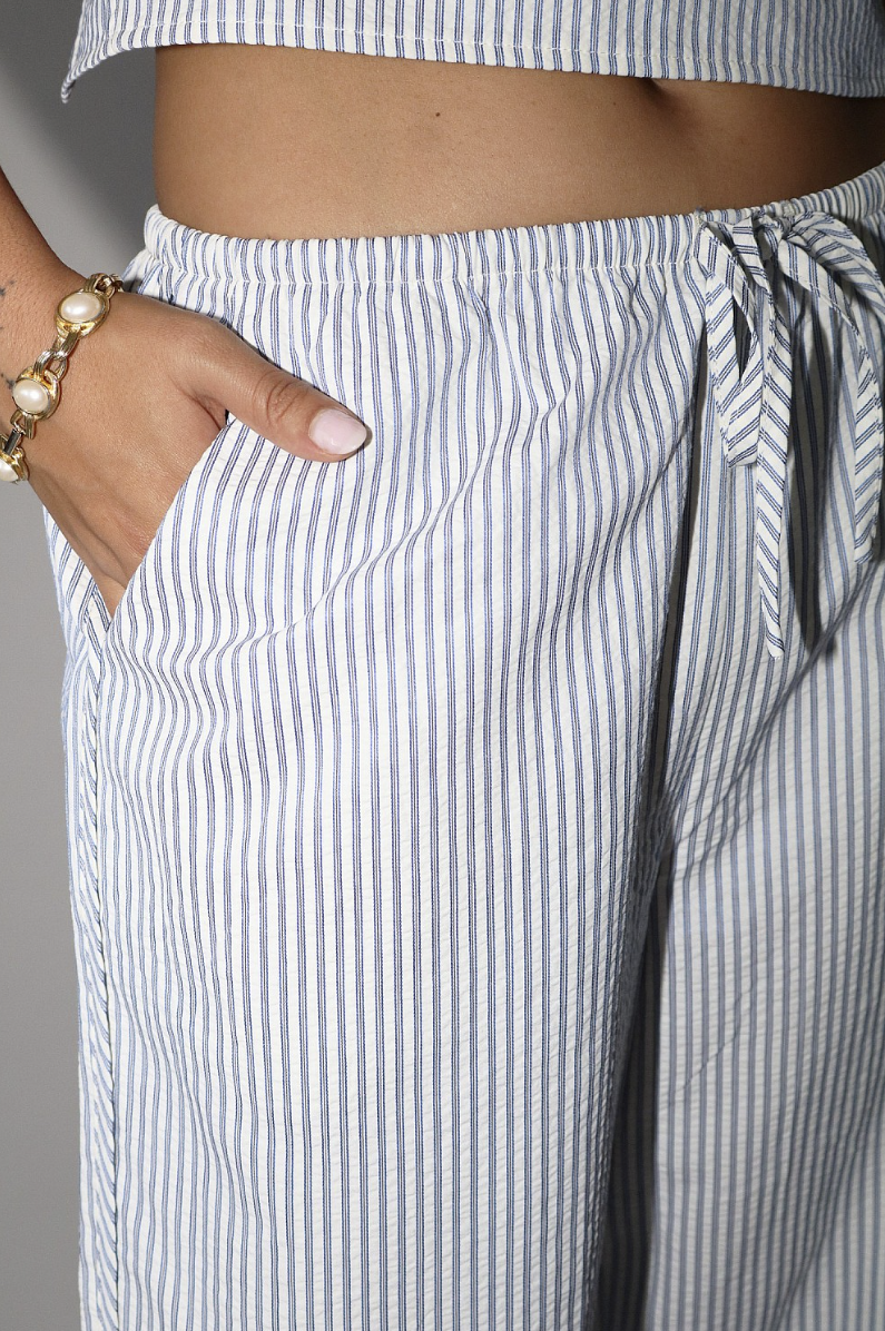 Striped pants with a drawstring waist, worn by a person.